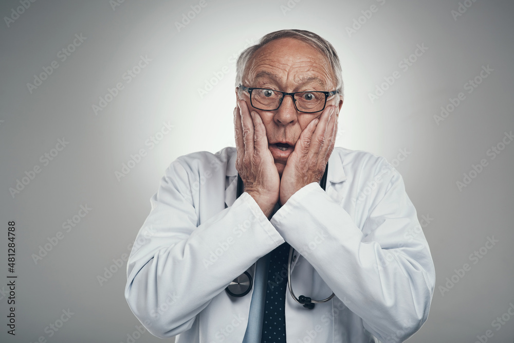 How will we solve this case. Shot of an elderly male doctor in a studio against a grey background. How will we solve this case. Shot of an elderly male doctor in a studio against a grey background.