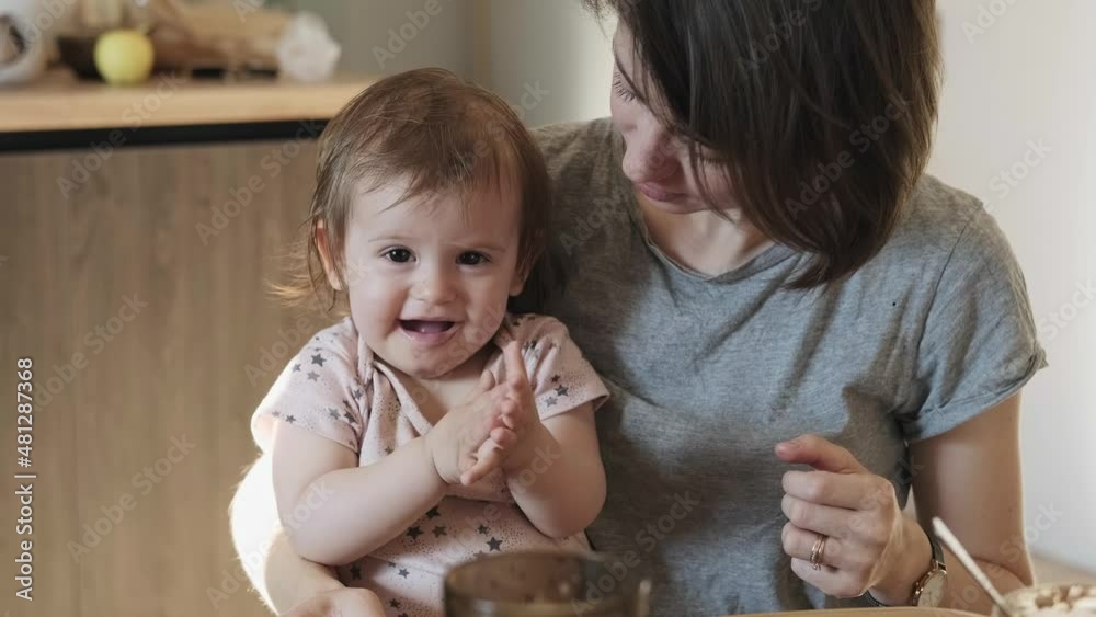 Mom holding a baby in hands and sprays a disinfectant antibacterial spray on her daughters hands. Family care. Family protection. Baby care.