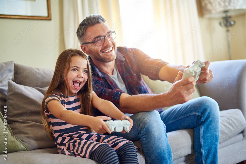 I'm beating you dad. Shot of a father and daughter playing video games. I'm beating you dad. Shot of a father and daughter playing video games.