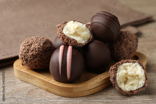 Many different delicious chocolate truffles on wooden table