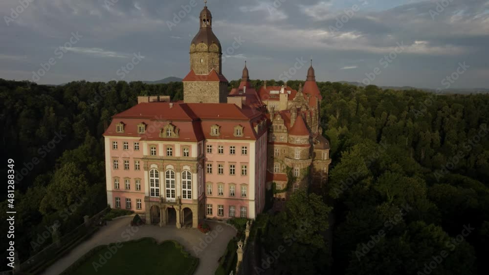 Aerial descending shot of the Ksiaz Castle (Schloss Furstenstein) in the early morning with dramatic clouds in the background Aerial descending shot of the Ksiaz Castle (Schloss Furstenstein) in the early morning with dramatic clouds in the background