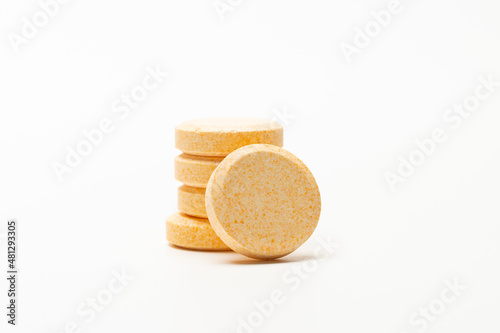 Image of orange soluble tablet or pills isolated on white background. This type of tablet can dissolve in water.  usually for vitamin, supplement or medicine.  photo