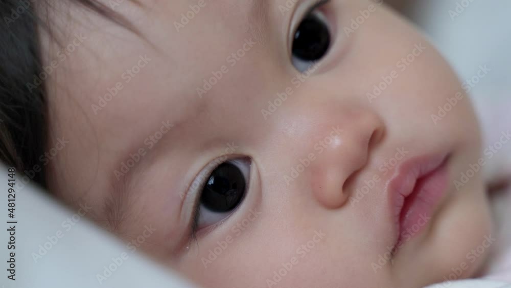 closeup baby infant blinking eyes and smile after drink milk from bottle. kid eye blink. happy smile baby face. asian child. closeup baby infant blinking eyes and smile after drink milk from bottle. kid eye blink. happy smile baby face. asian child.