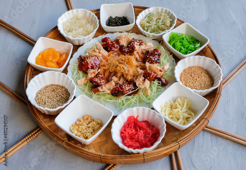 Modern Chinese fish salad. Lo Hei aka Prosperity Toss. Small bowls of peeled mandarins, pomelo, crushed peanuts, sesame seeds, pickled ginger, radish, smoked salmon, baby octopus and jellyfish photo