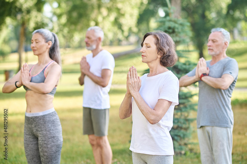Group of people meditating together in park