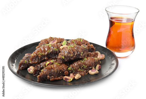 Delicious baklava with pistachios and hot tea on white background