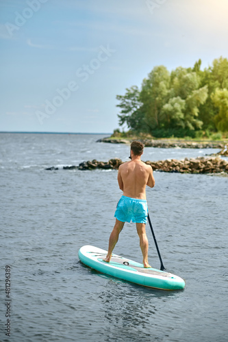 A man in blue swimming shorts with a kayak