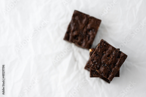 flat lay of stack of brownies (soft focus) with white backing sheet