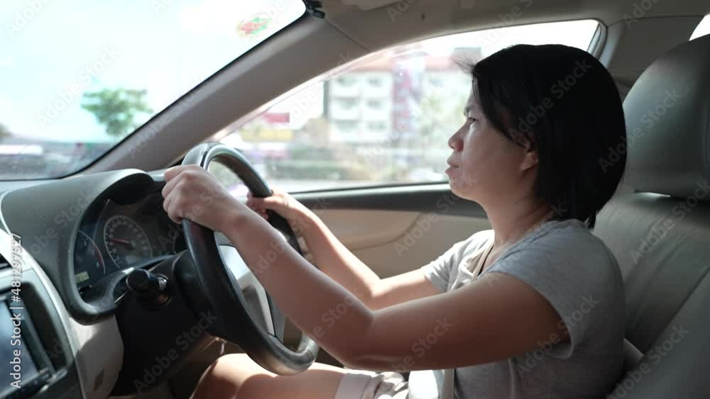 Female Asian driver fasten seatbelt and driving a car in highway for travel a vacation trip Female Asian driver fasten seatbelt and driving a car in highway for travel a vacation trip