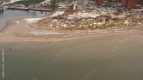 An aerial view of Coney Island Creek, NY on a winter morning. The drone camera truck right over the creek with apartment buildings and the beach in the background on a cloudy day. photo