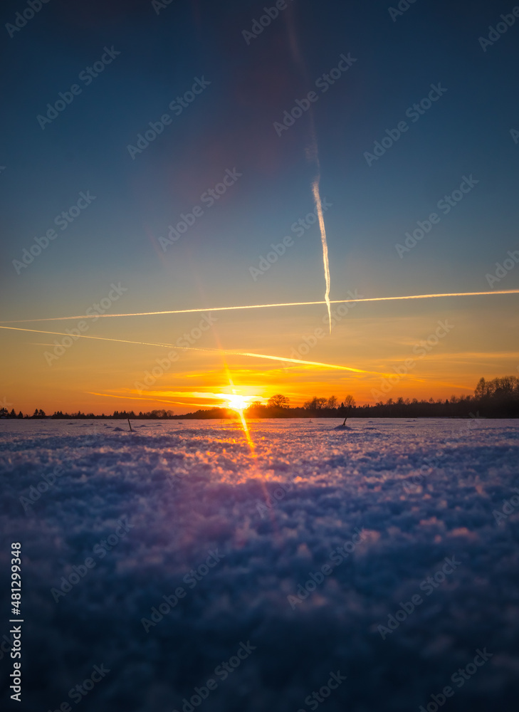 A beautiful winter landscape during sunrise from a low perspective. Snowy morning scenery of Northern Europe.