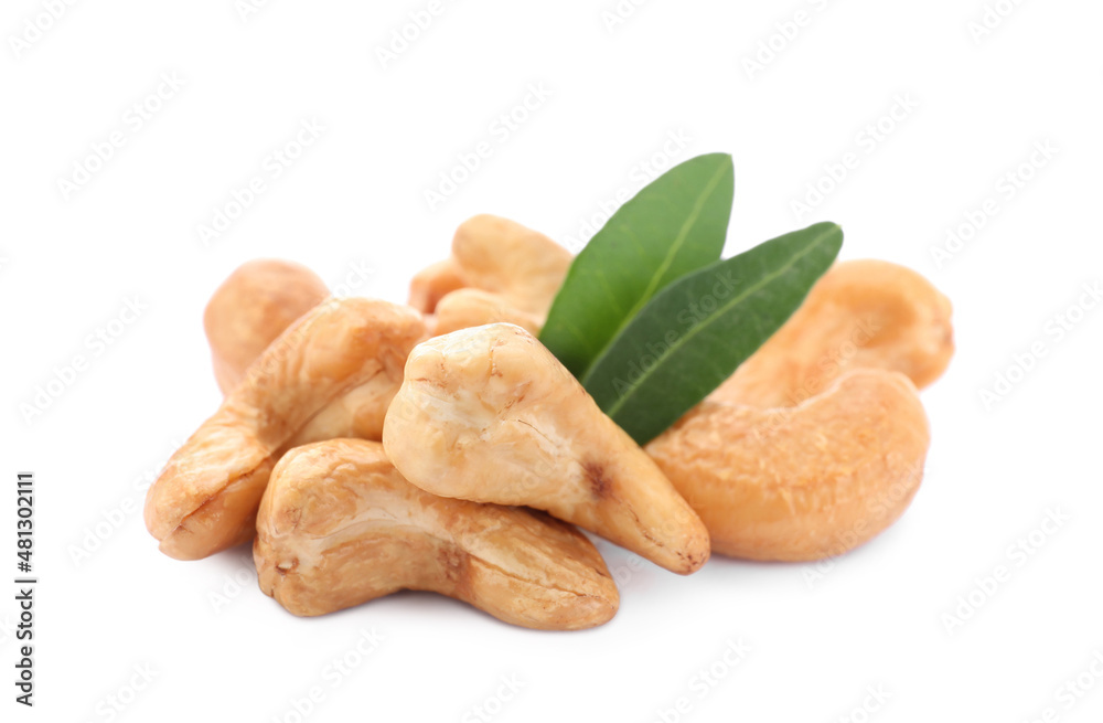 Fototapeta premium Pile of tasty organic cashew nuts and green leaves isolated on white