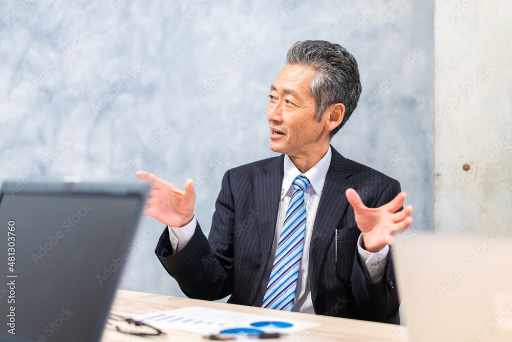 スーツで意見を述べる経営者 スーツで意見を述べる経営者