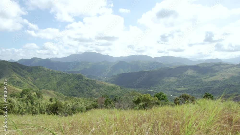 This is a hand-held shot of the view at the 2nd summit of Mt. Batolusong trail. A grassy peak with a view of Sierra Madre Mountain Ranges on a sunny day. This is a hand-held shot of the view at the 2nd summit of Mt. Batolusong trail. A grassy peak with a view of Sierra Madre Mountain Ranges on a sunny day.