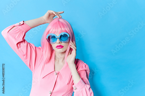 portrait of a woman in blue glasses wears a pink wig studio model unaltered