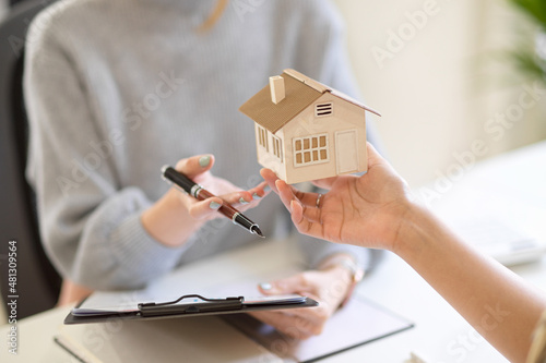A property investor holding a house model, looking a house model. photo
