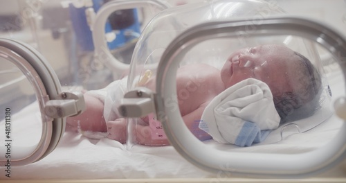 Bild auf Leinwand Closeup lovely little newborn baby infant lying in incubators for newborns, Newb