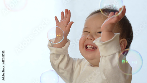 シャボン玉で遊ぶ笑顔のハーフの赤ちゃん