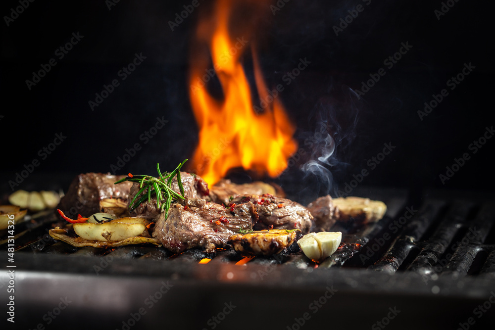 Beef steaks pieces of meat on the grill with flames. American cuisine. The concept cooking meat. Food recipe background. Close up. place for text Beef steaks pieces of meat on the grill with flames. American cuisine. The concept cooking meat. Food recipe background. Close up. place for text