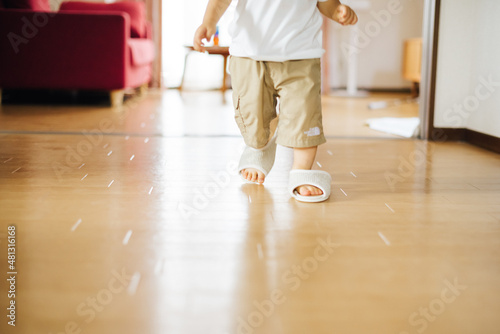 スリッパを履いて室内を歩く子供 © kotoko