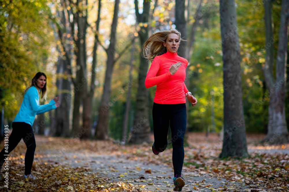 Woman Exercising in Public Park with Personal Trainer. Trainer Cheering and Woman Running Woman Exercising in Public Park with Personal Trainer. Trainer Cheering and Woman Running