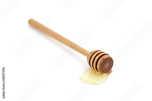Wooden honey stick with drop isolated on white