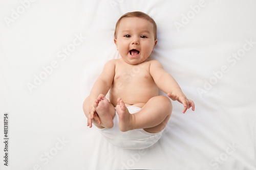 Baby girl lying on her back smiling at camera photo