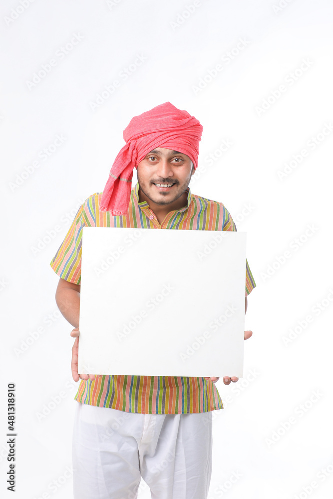 Young indian farmer holding white card board on white background. Young indian farmer holding white card board on white background.