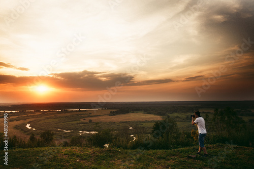 man photographs the sunset. Landscape. Photographer. Beautiful nature. Open space and sun. Traveller