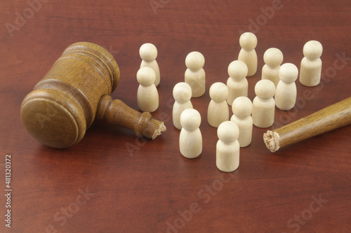 People breaking and changing laws and freedom concept. Wooden figures of people and broken judge gavel.