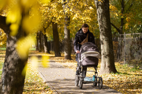 Happy young father with pram during the walk in nature photo