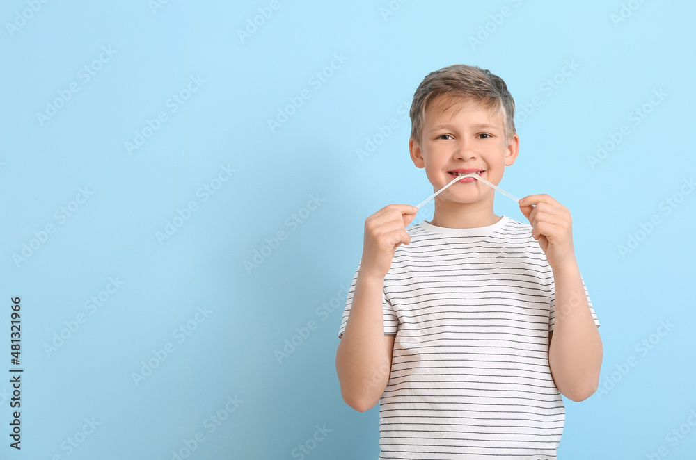 Little boy in striped t-shirt chewing gum on blue background Little boy in striped t-shirt chewing gum on blue background
