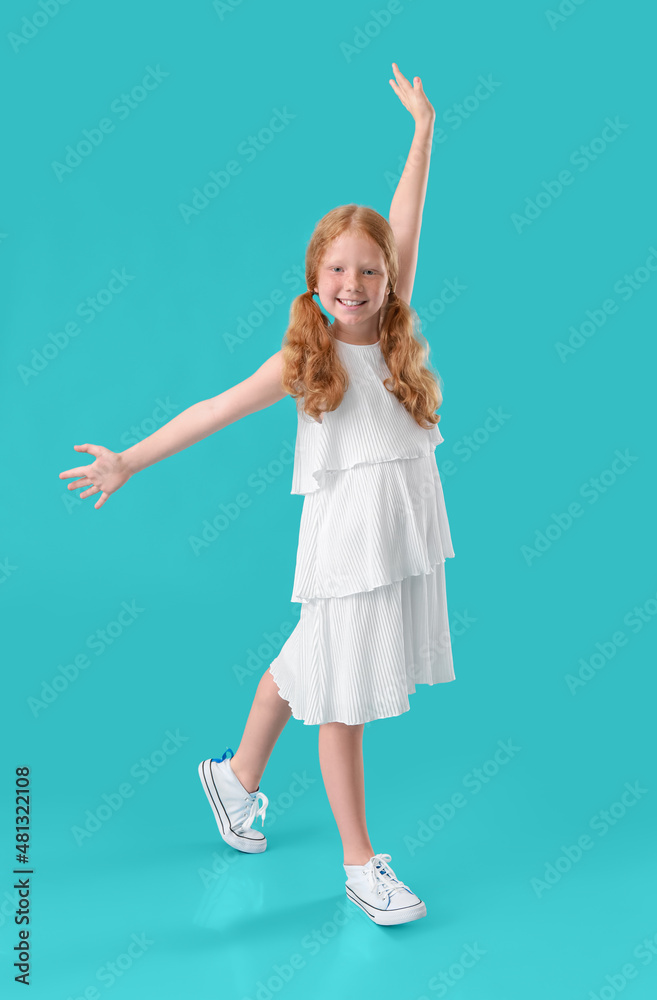 Little redhead girl in white dress dancing on blue background Little redhead girl in white dress dancing on blue background