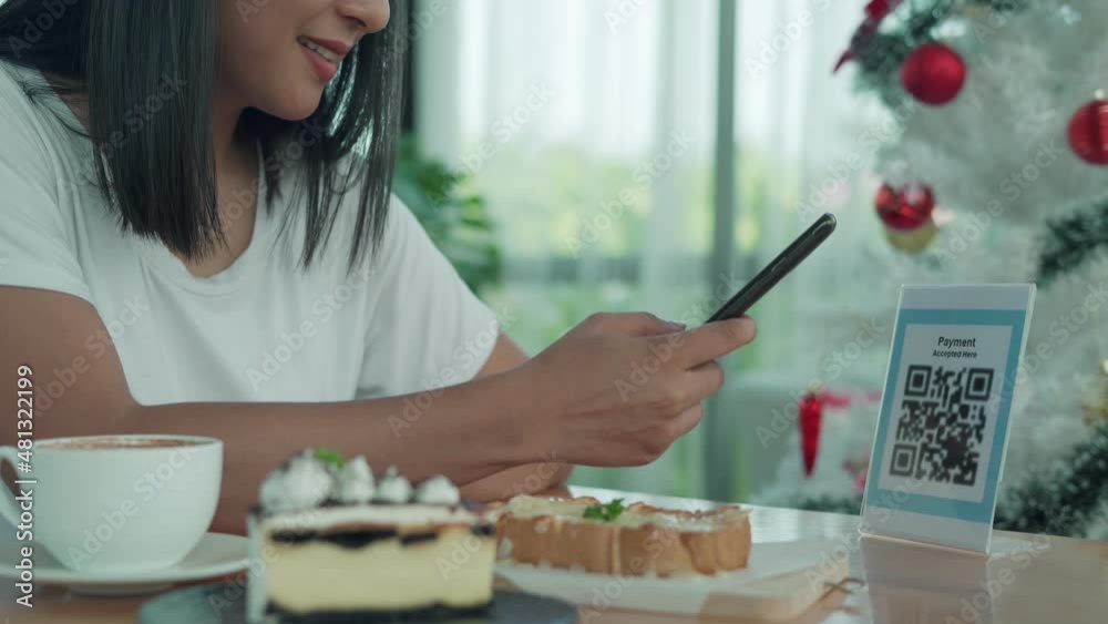 Beautiful woman scan barcodes for order. Women using their mobile phones for scanning to pay for coffee and bakery on cafe .Concept technology for pay by scan QR code help social distance.