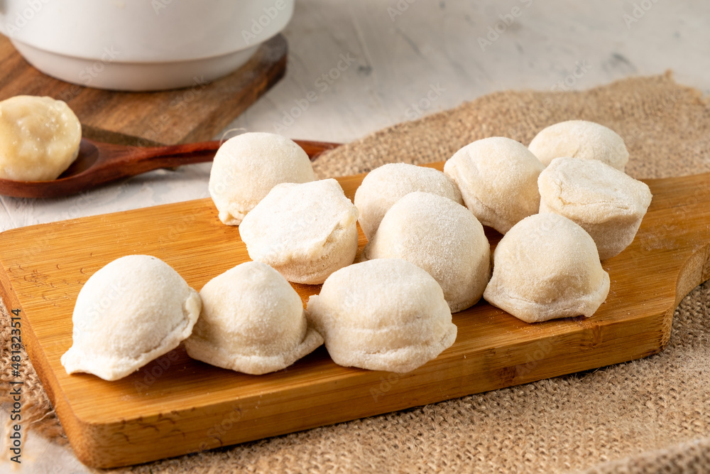 Raw dumplings on a wooden board, light table. Raw dumplings on a wooden board, light table.