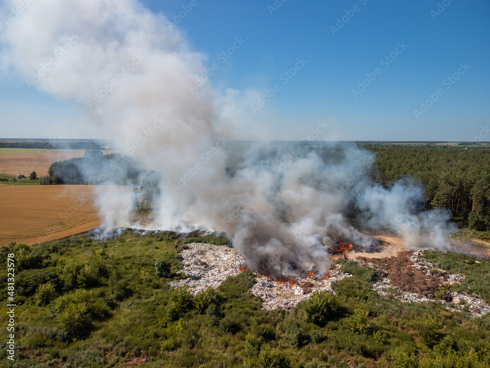 Aerial photo of garbage dump in fire in the countryside. Environmental pollution by burning different types of rubbish