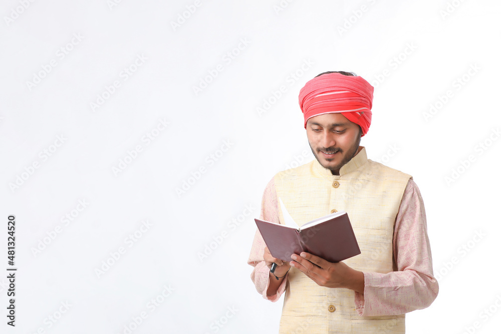 Indian farmer using diary on white background. Indian farmer using diary on white background.