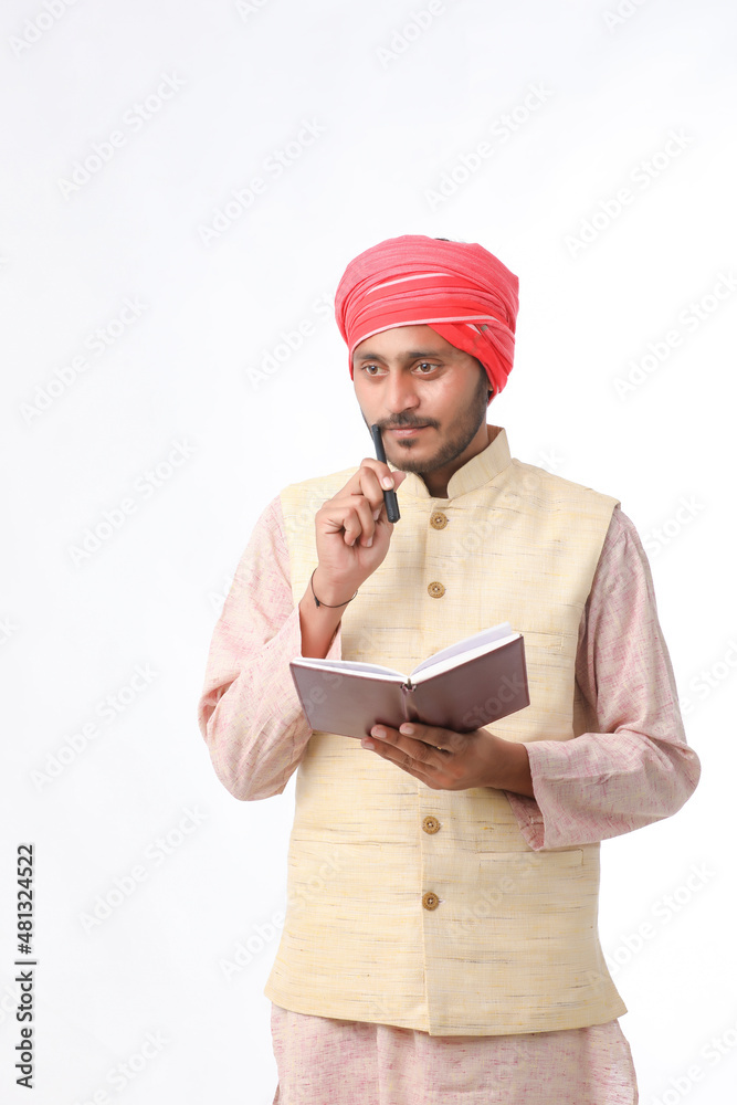 Indian farmer using diary on white background. Indian farmer using diary on white background.