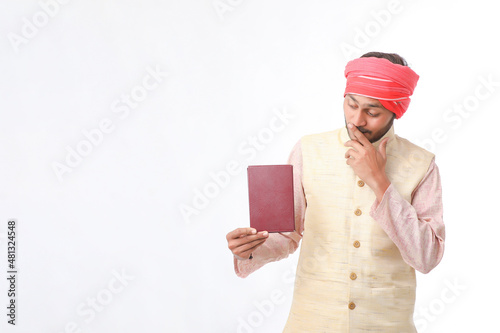 Indian farmer using diary on white background. photo