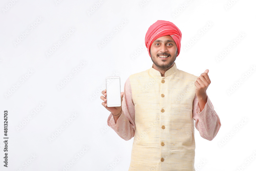 Young indian man showing smartphone and giving expression on white background. Young indian man showing smartphone and giving expression on white background.