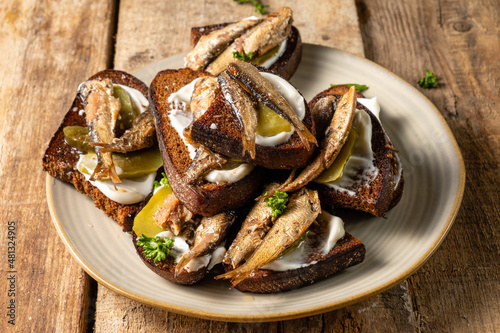 A plate with an appetizer of bread with smoked sprats.