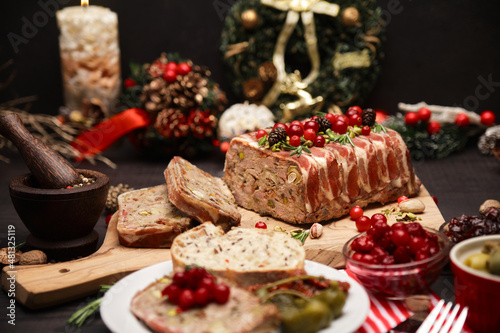 Fototapeta Naklejka Na Ścianę i Meble -  Traditional French terrine covered with bacon on dark wooden background with Christmas decorations