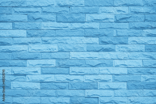 Brick wall painted with blue dark paint pastel calm tone texture background. Brickwork and stonework flooring interior rock old pattern clean concrete grid uneven bricks design stack backdrop.