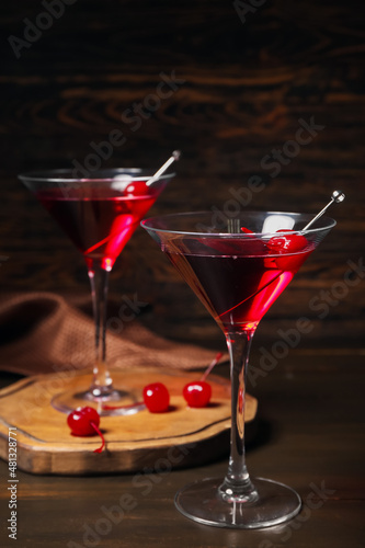 Glasses of tasty Manhattan cocktail on dark wooden background