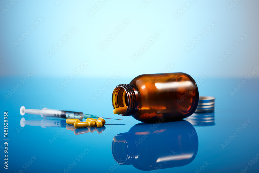Spilled pills bottle on blue background Spilled pills bottle on blue background