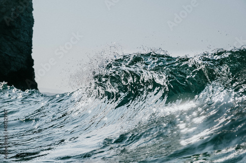 Fotografi Silver waves crashes with harsh sunlight