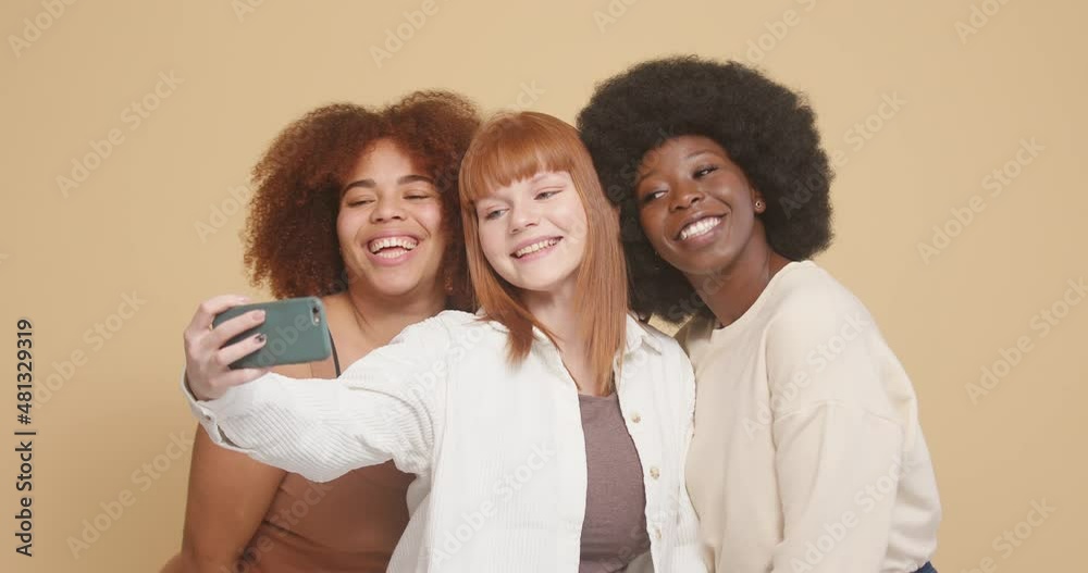 Women of different races pose taking selfies via smartphone Women of different races pose taking selfies via smartphone