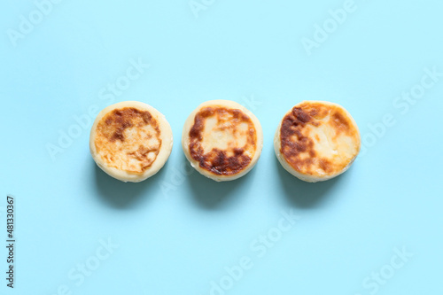 Tasty cottage cheese pancakes on blue background