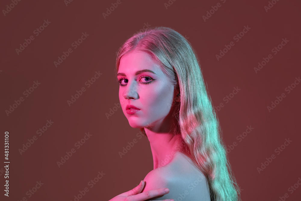 Beautiful girl with stylish makeup on color background