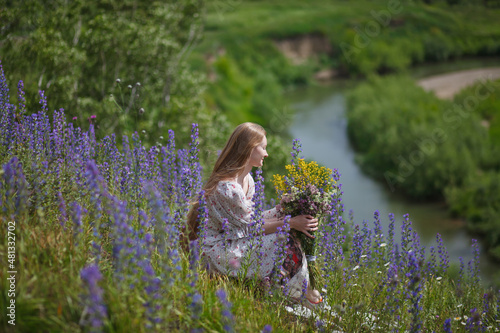 Medieval lady in historical dress. Aroma of spring nature, wild flowers, blue sky, sunshine.